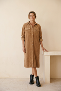 Vestido Estela de pana con modelo junto a un banco claro
